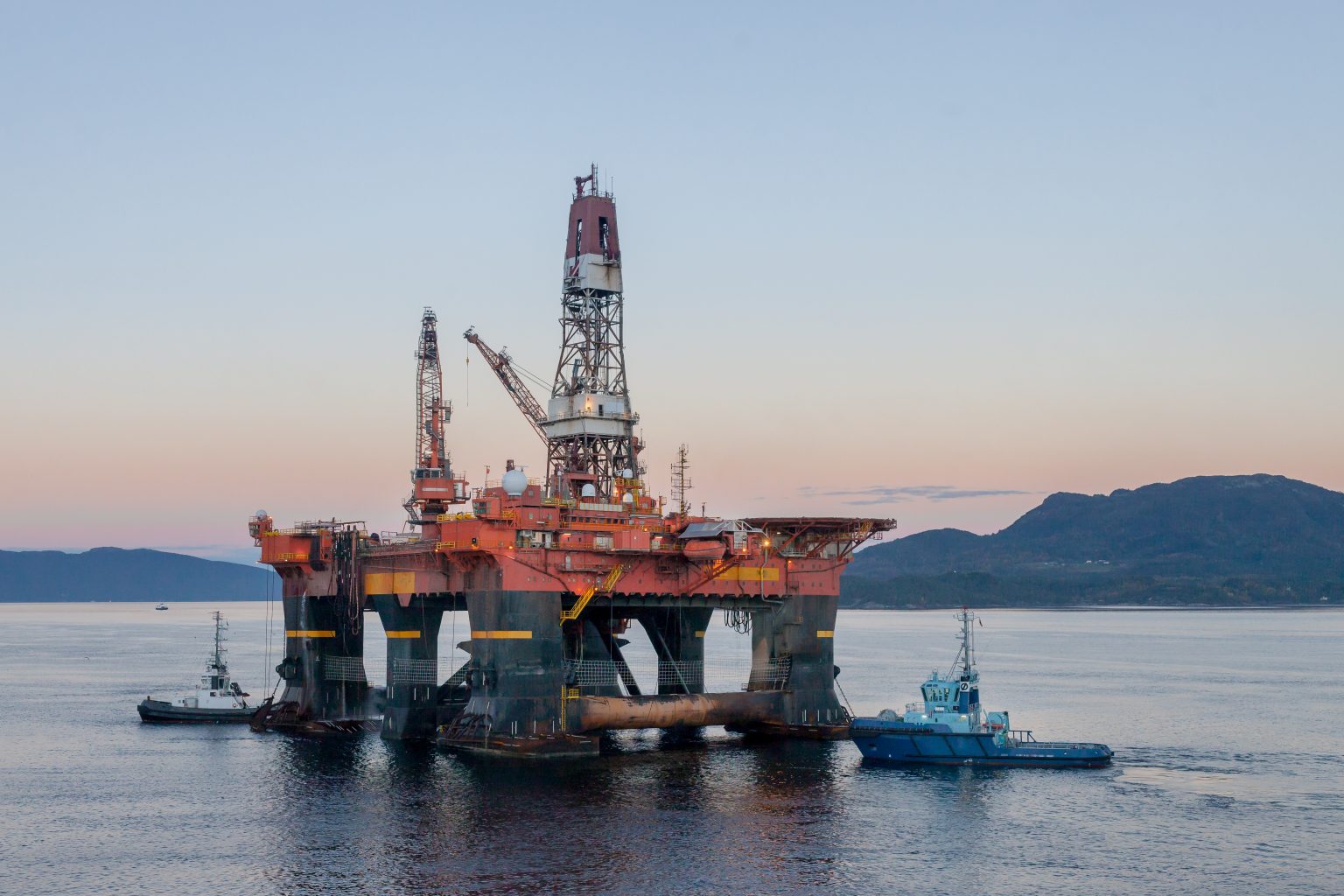 OELEN NORWAY - 2014 OCTOBER 16. The semi-submersible drilling rig West Alpha inside the Norwegian fjord in the morning with tug boats.